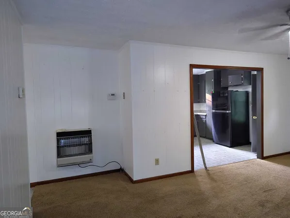 a view of an empty room and kitchen