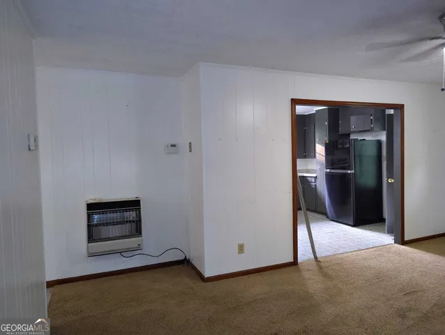a view of an empty room and kitchen