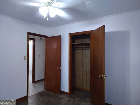 a view of a hallway with a chandelier fan and kitchen view