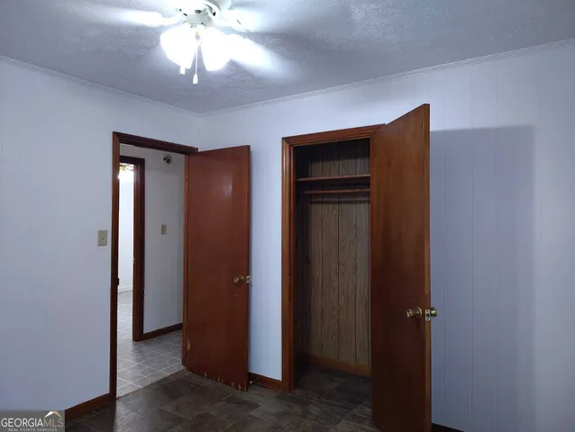 a view of a hallway with a chandelier fan and kitchen view