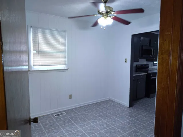 a view of empty room with a ceiling fan and a window