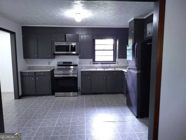 a kitchen with stainless steel appliances granite countertop a stove a refrigerator and a sink