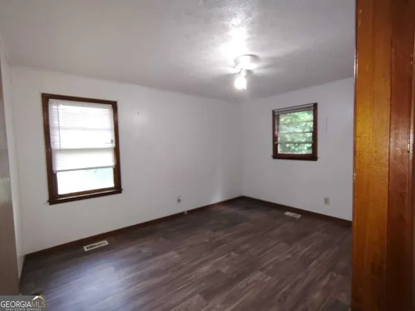 an empty room with windows and closet