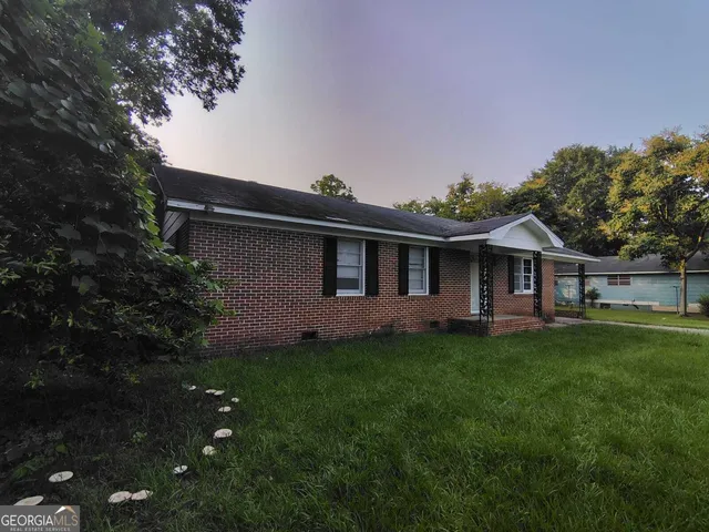 a backyard of a house with table and chairs