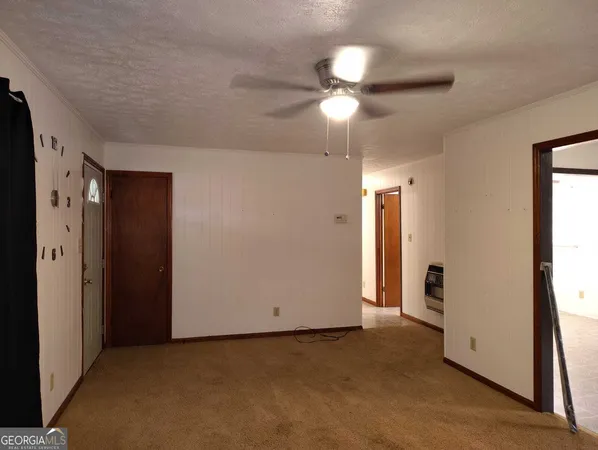 an empty room with closet and a chandelier fan