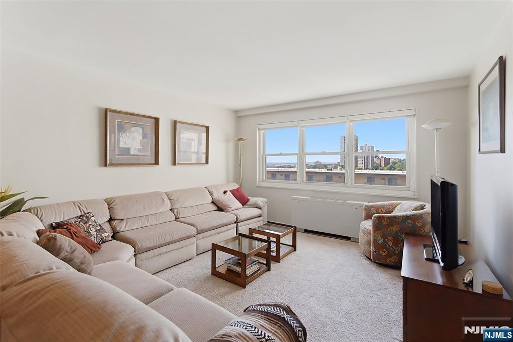 280 Prospect Avenue, Unit 8G Hackensack, NJ 07601 - Photo 10 of 23 a living room with furniture a flat screen tv and a window