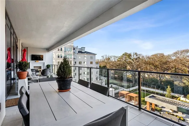 a balcony with couches and a potted plant on a table