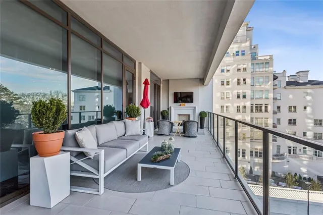 a view of a balcony with chairs and potted plants