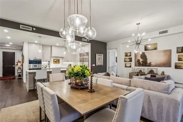 a living room with furniture kitchen view and a chandelier