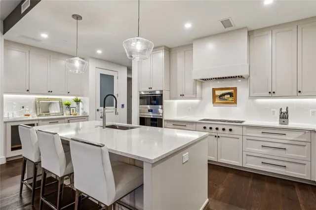 a kitchen with stainless steel appliances granite countertop a stove a sink and a microwave
