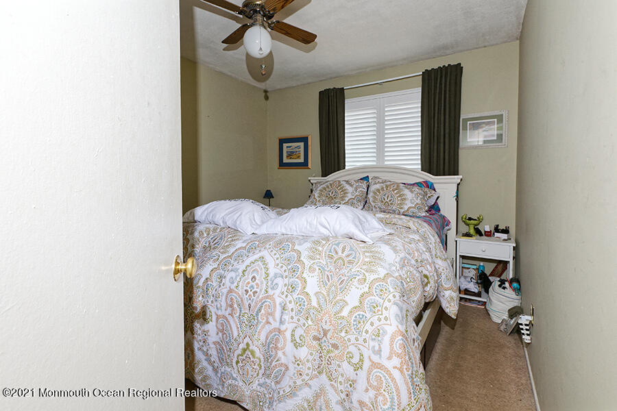 458 Dover Road Toms River, NJ 08757 - Photo 9 of 13 a bedroom with a bed and a chandelier