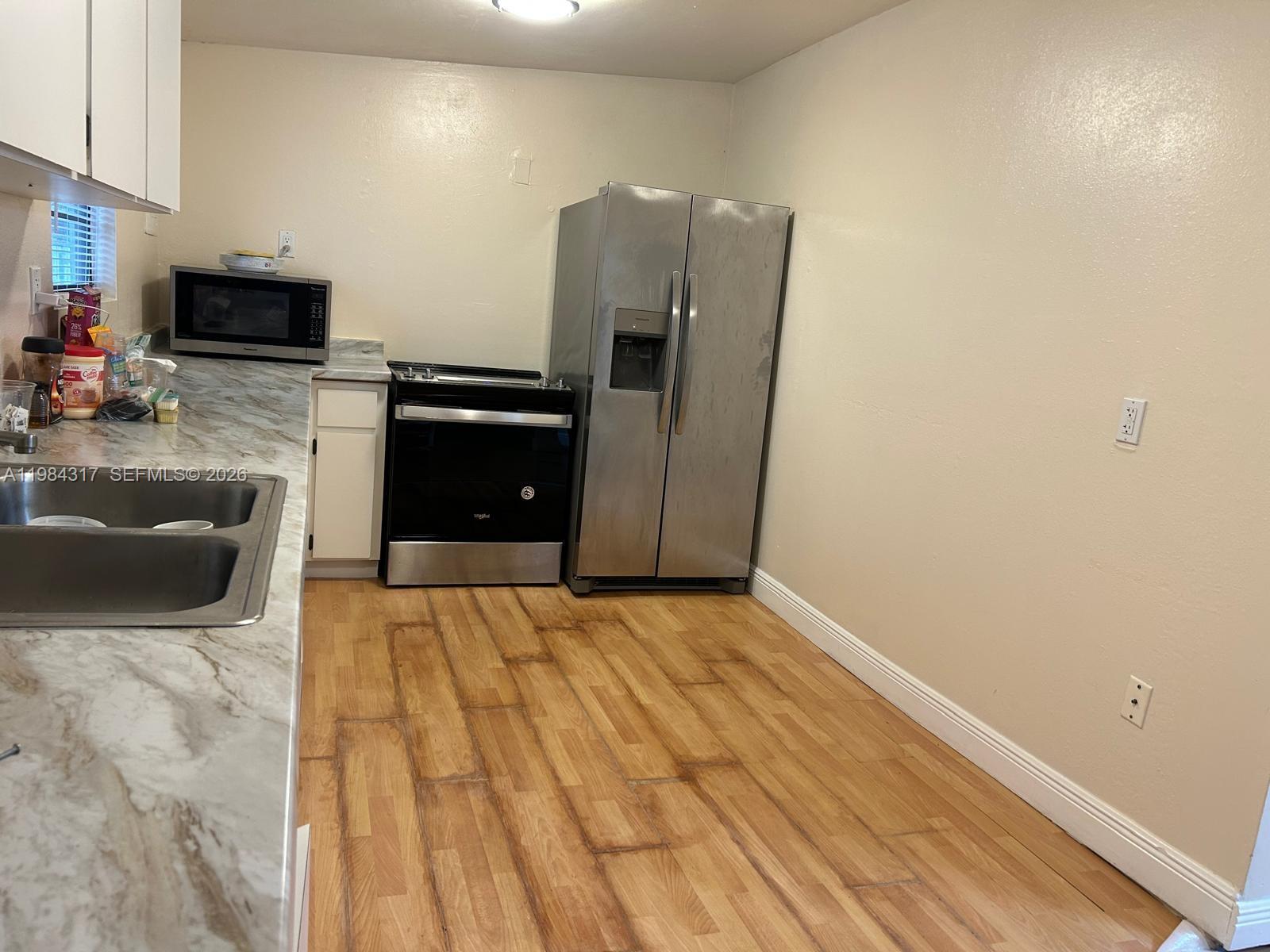 8866 Southwest 126th Street Miami, FL 33176 - Photo 18 of 20 a kitchen with granite countertop a refrigerator and a stove top oven