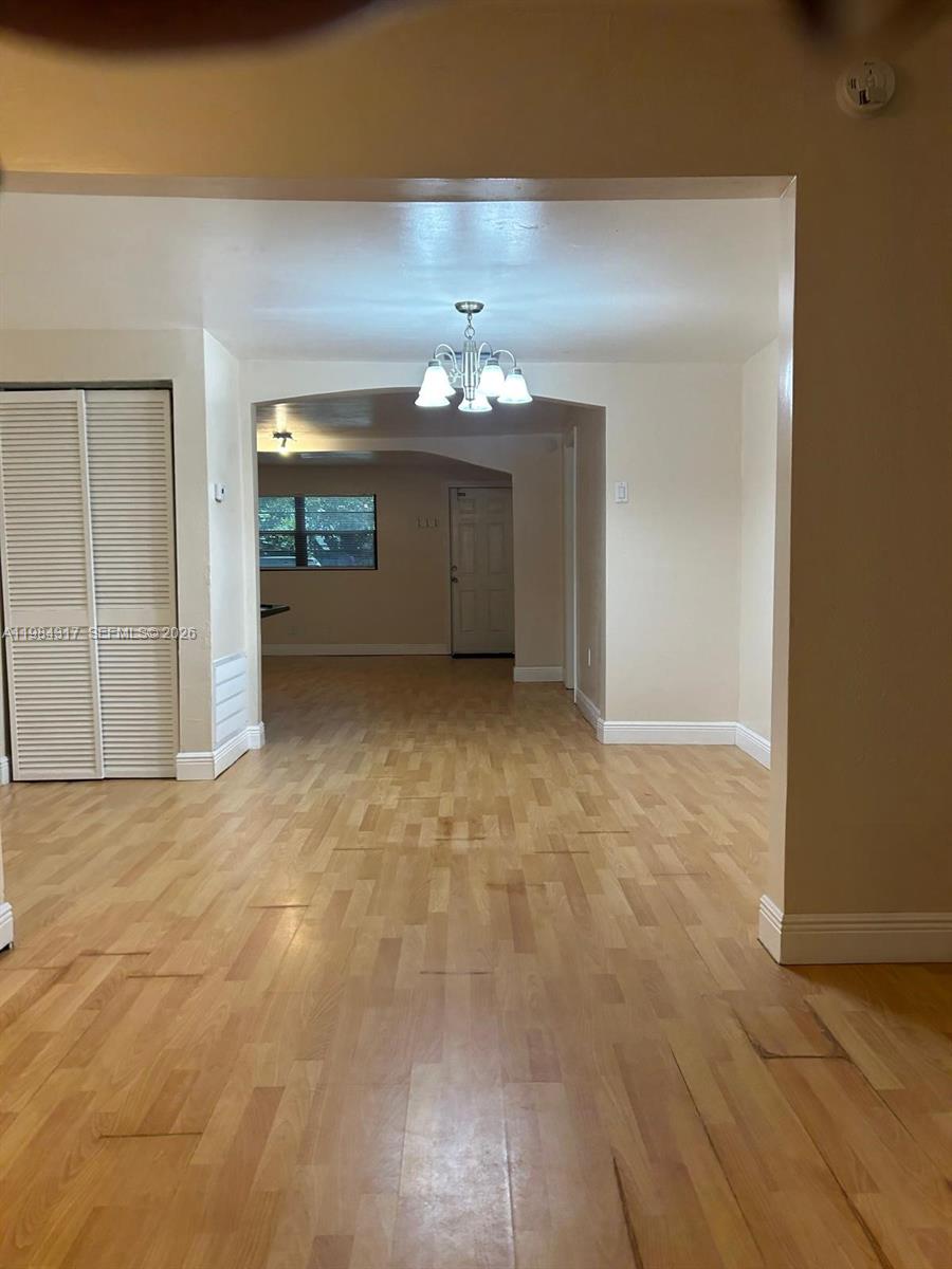 8866 Southwest 126th Street Miami, FL 33176 - Photo 19 of 20 en empty room with a fireplace and chandelier fan