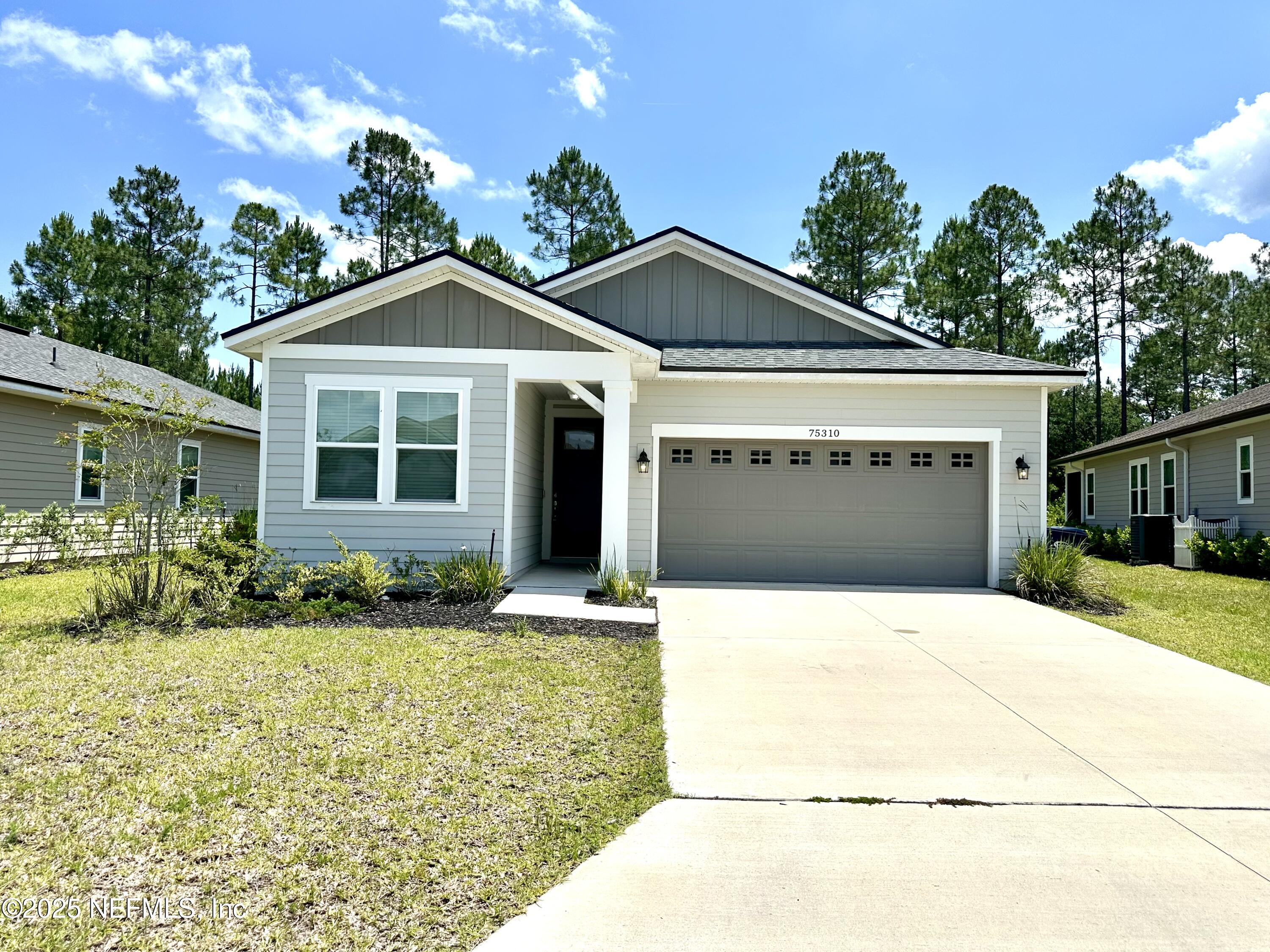 75310 White Rabbit Avenue Yulee, FL 32097 - Photo 2 of 61 a front view of a house with a yard and garage