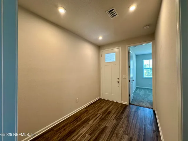 a view of empty room with window and ceiling fan