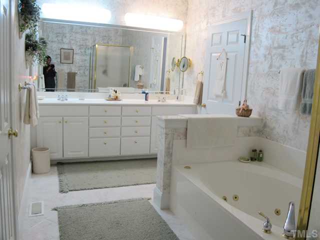 3401 Barron Berkeley Way Raleigh, NC 27612 - Photo 16 of 25 a bathroom with a double vanity sink a mirror and a bathtub
