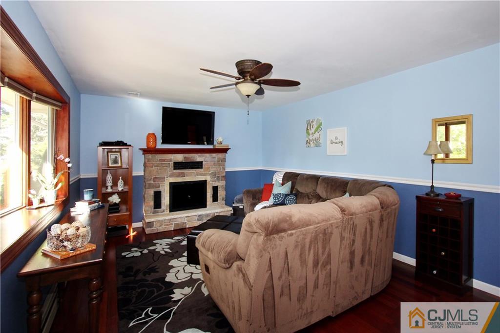 60 Morningside Road Colonia, NJ 07067 - Photo 2 of 21 a living room with furniture a flat screen tv and a fireplace
