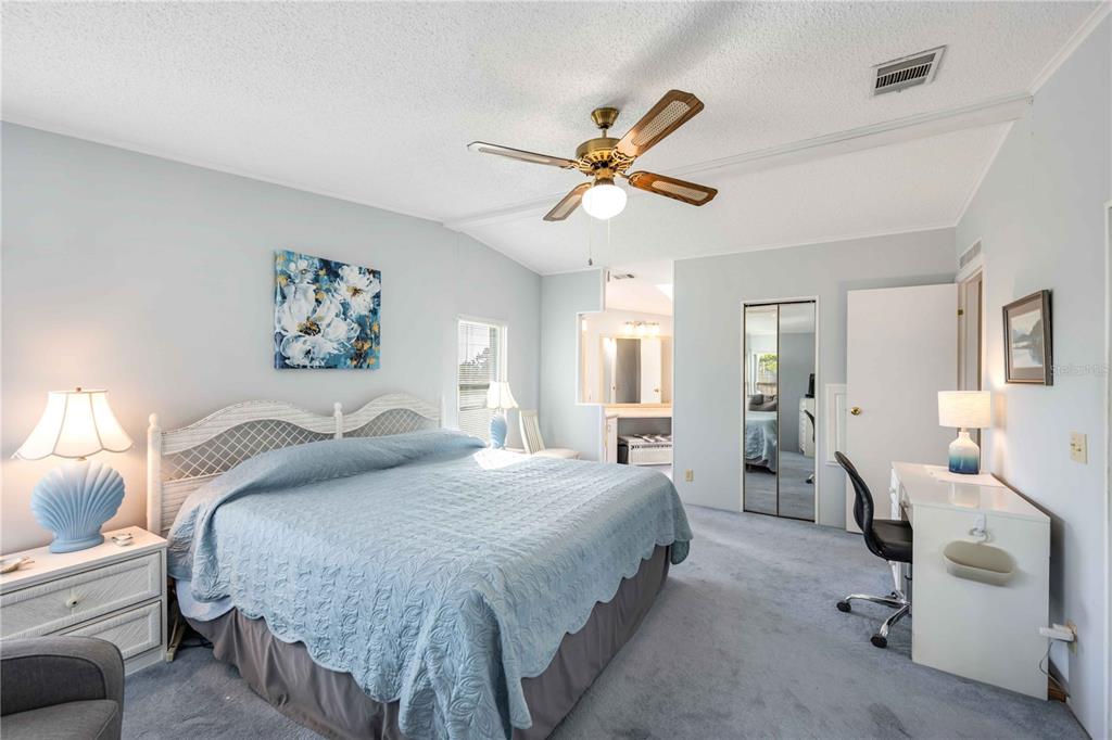 15550 Burnt Store Road, Unit 22 Punta Gorda, FL 33955 - Photo 11 of 39 a bedroom with a bed and ceiling chandelier