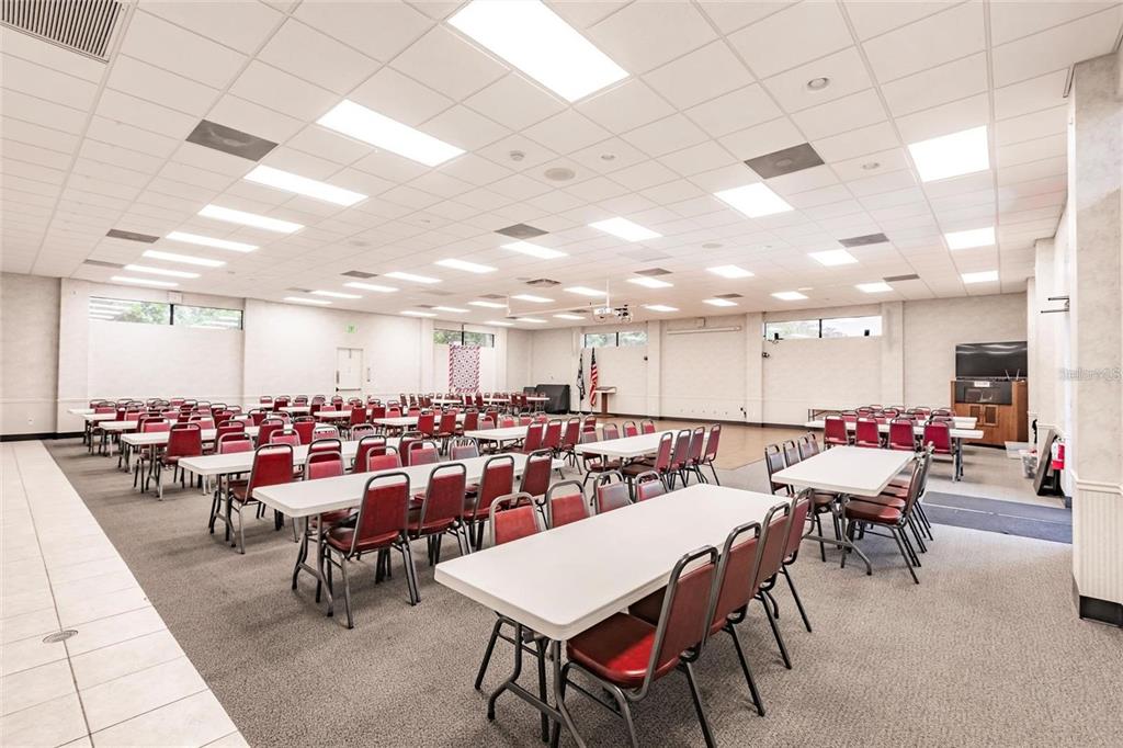15550 Burnt Store Road, Unit 22 Punta Gorda, FL 33955 - Photo 28 of 39 a room with lots of chairs a desk and a chandelier