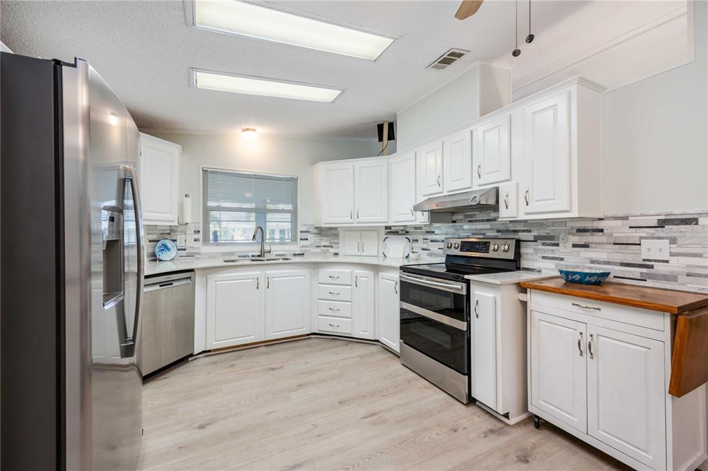 15550 Burnt Store Road, Unit 22 Punta Gorda, FL 33955 - Photo 3 of 39 a kitchen with white cabinets stainless steel appliances and sink