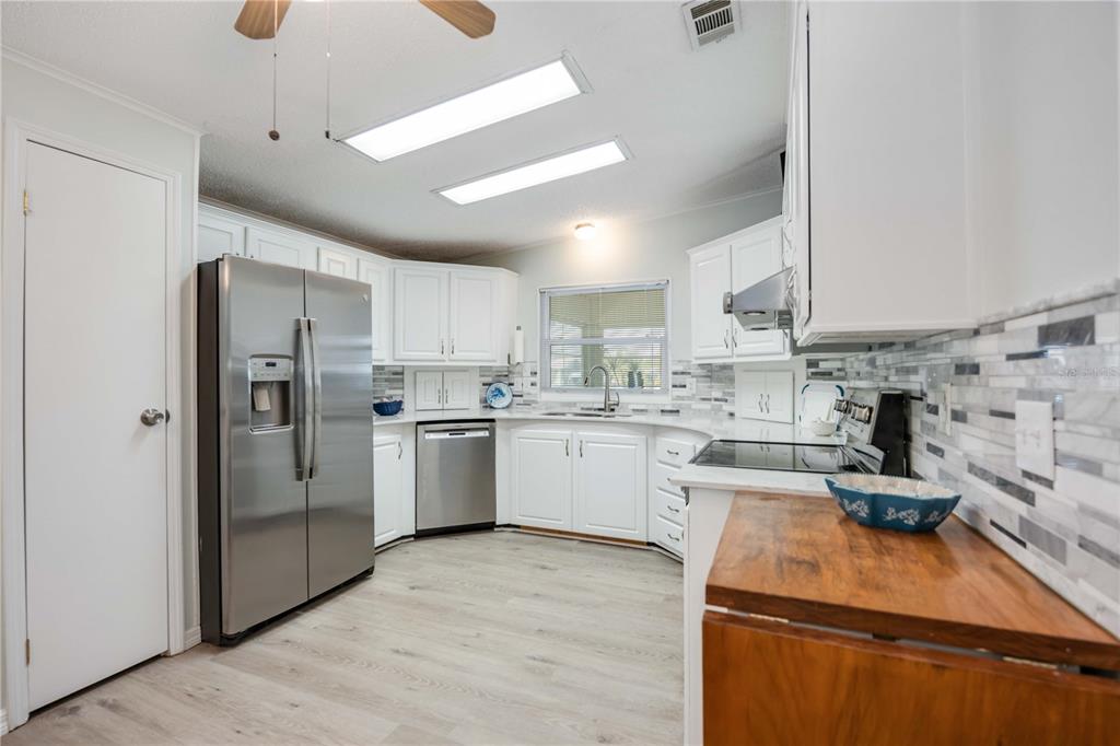 15550 Burnt Store Road, Unit 22 Punta Gorda, FL 33955 - Photo 4 of 39 a kitchen with a refrigerator a sink and white cabinets