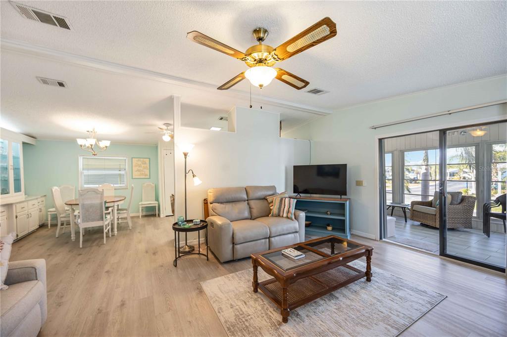 15550 Burnt Store Road, Unit 22 Punta Gorda, FL 33955 - Photo 10 of 39 a living room with furniture a flat screen tv and a floor to ceiling window