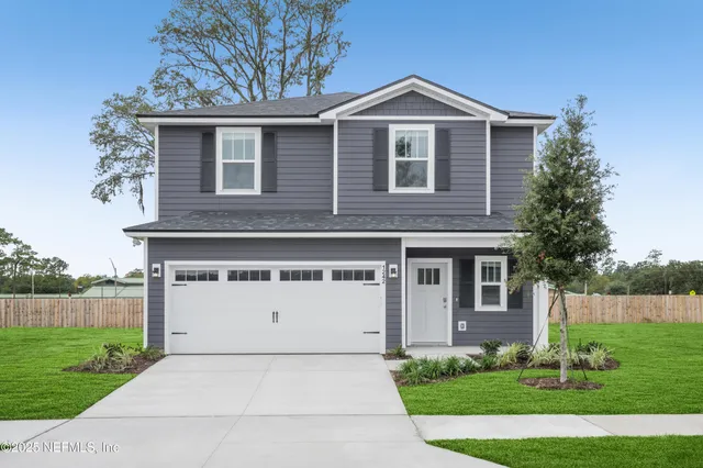 a front view of a house with a yard and garage