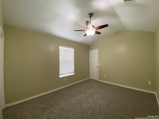 an empty room with a window and a fan