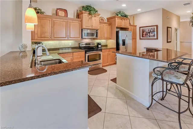a kitchen with stainless steel appliances granite countertop a refrigerator a sink a stove and cabinets