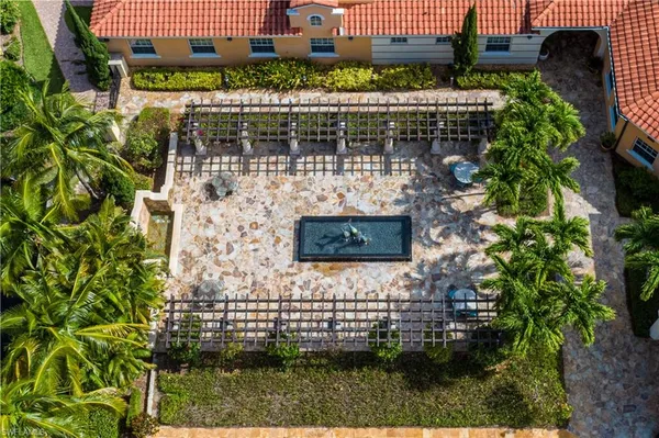 a view of a brick house with a yard and potted plants