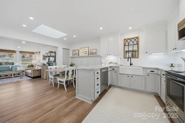 a kitchen with a sink stainless steel appliances and white cabinets