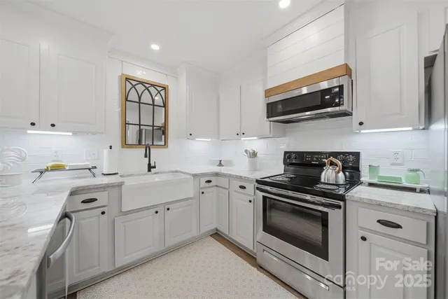 a kitchen with stainless steel appliances granite countertop a sink stove oven and cabinets