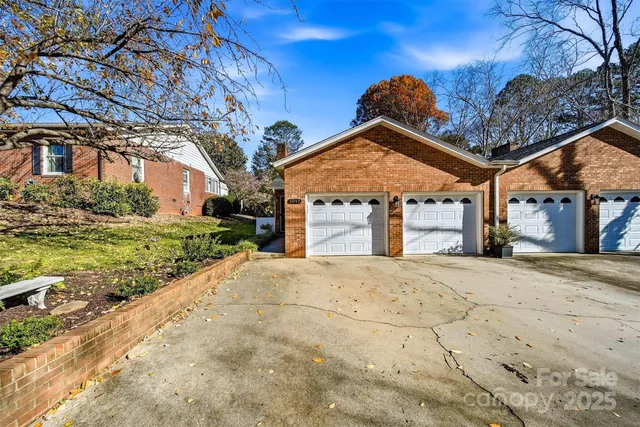 a front view of a house with garden and trees