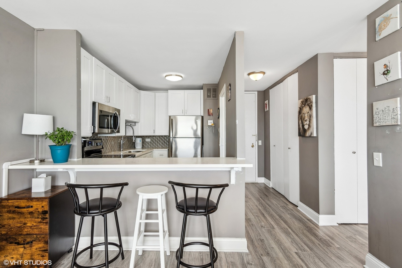 5445 North Sheridan Road, Unit 1905 Chicago, IL 60640 - Photo 6 of 10 a kitchen with stainless steel appliances a dining table chairs microwave and refrigerator
