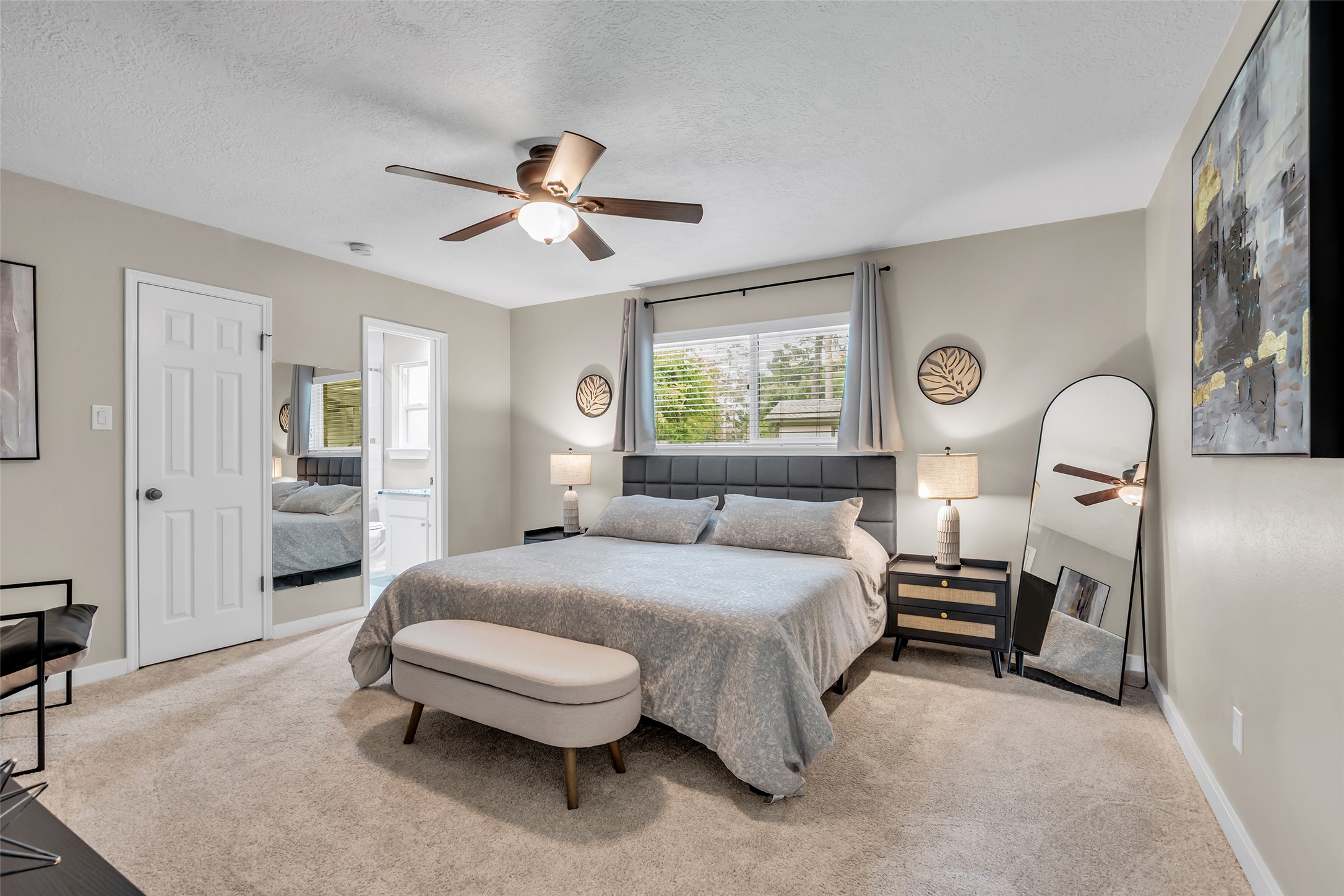 22502 Fields Lane Spring, TX 77389 - Photo 19 of 39 Primary bedroom features a cozy carpet, neutral walls, and a stylish ceiling fan. It includes a large window for natural light. A door leads to an ensuite bathroom for added convenience.