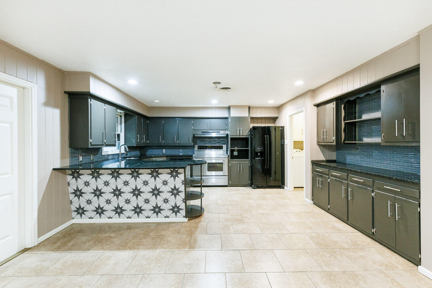 3515 36th Street Lubbock, TX 79413 - Photo 20 of 63 a large kitchen with stainless steel appliances kitchen island granite countertop a refrigerator and a stove top oven