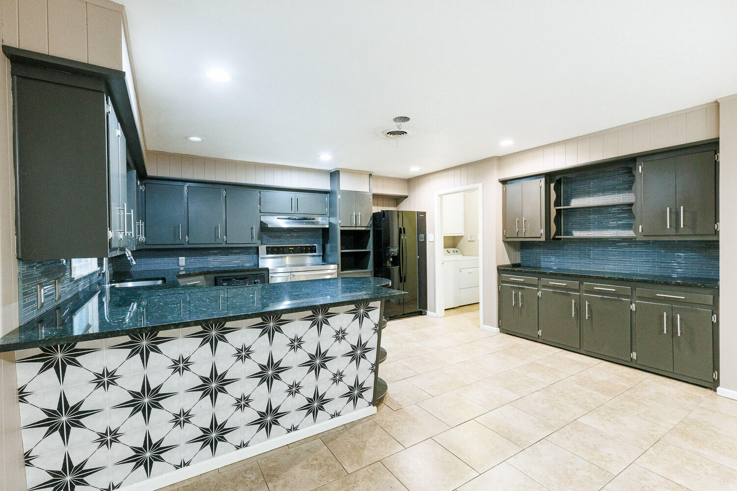 3515 36th Street Lubbock, TX 79413 - Photo 21 of 63 a large kitchen with granite countertop a sink and a stove top oven