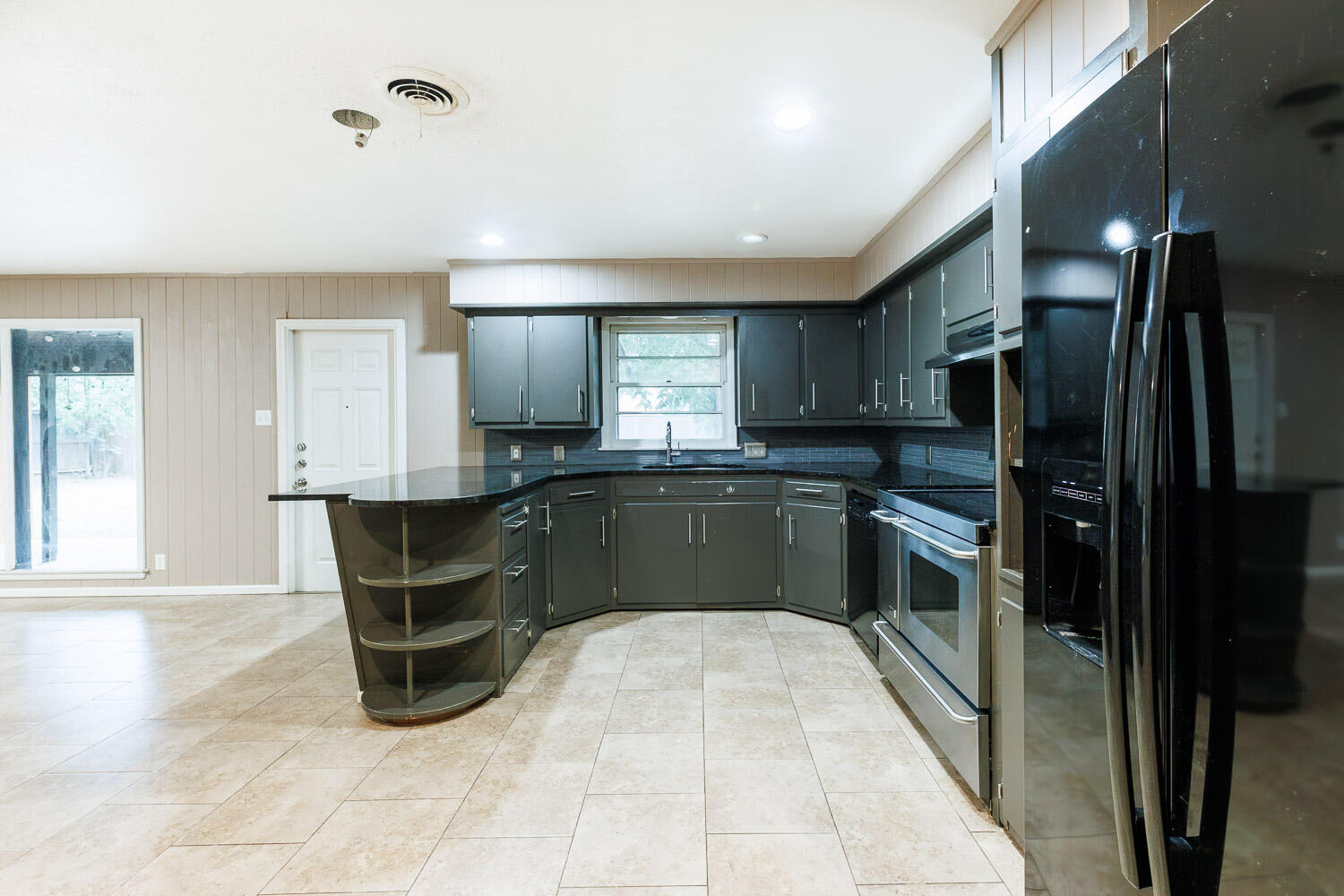 3515 36th Street Lubbock, TX 79413 - Photo 24 of 63 a large kitchen with granite countertop a refrigerator and a sink