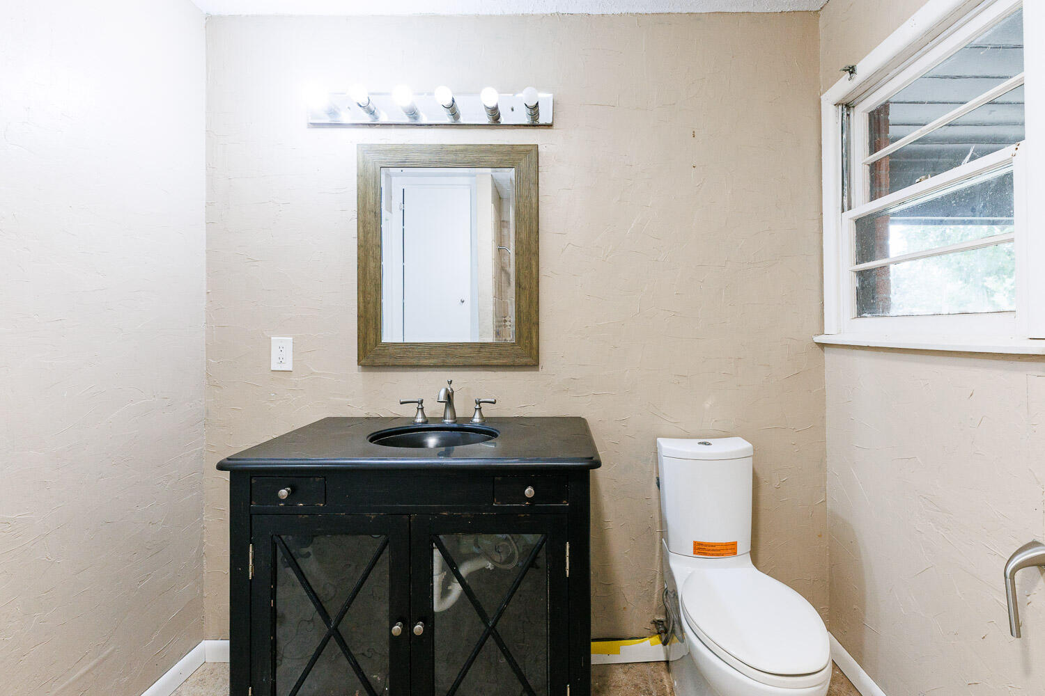 3515 36th Street Lubbock, TX 79413 - Photo 51 of 63 a bathroom with a toilet sink and mirror