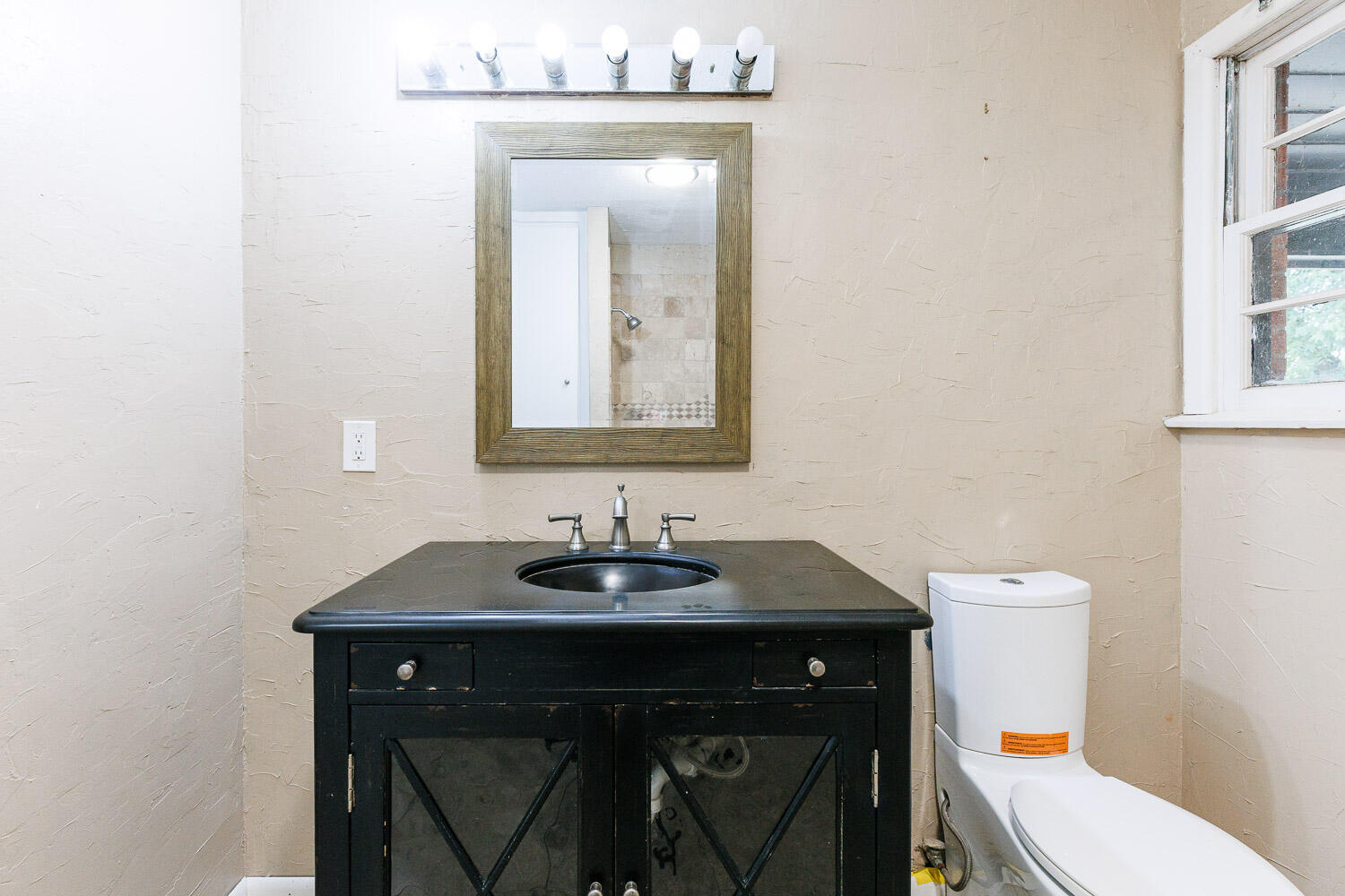 3515 36th Street Lubbock, TX 79413 - Photo 52 of 63 a bathroom with a toilet sink and mirror
