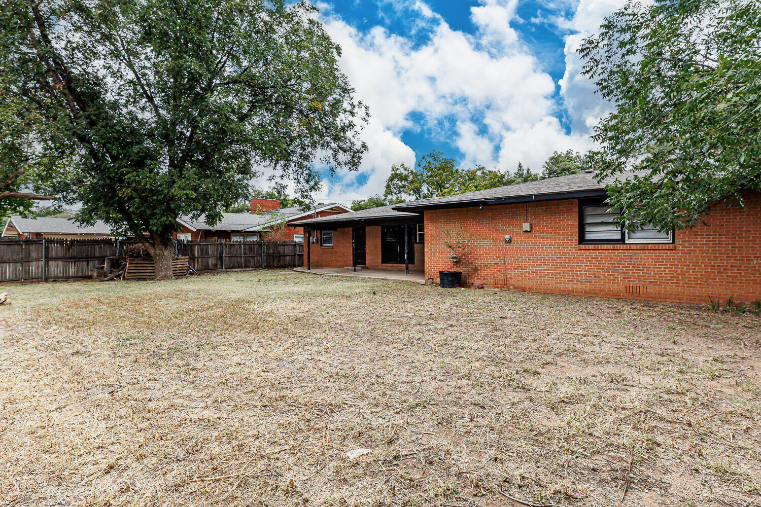 3515 36th Street Lubbock, TX 79413 - Photo 63 of 63 a backyard of a house with large trees and barbeque oven
