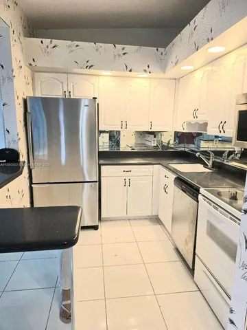 a kitchen with stainless steel appliances granite countertop a sink and a stove