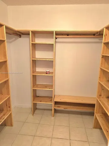 a view of walk in closet with empty racks