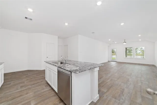 a kitchen with granite countertop white cabinets stainless steel appliances and sink