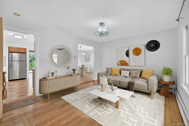 a living room with furniture kitchen view and a wooden floor