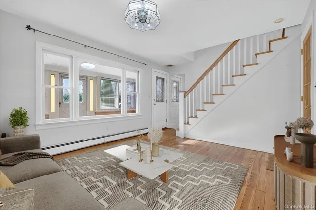 a view of a livingroom with furniture wooden floor and windows