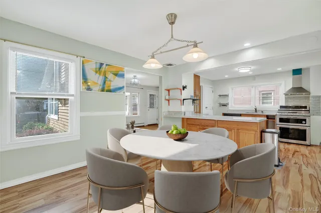 a kitchen with stainless steel appliances granite countertop a dining table and chairs
