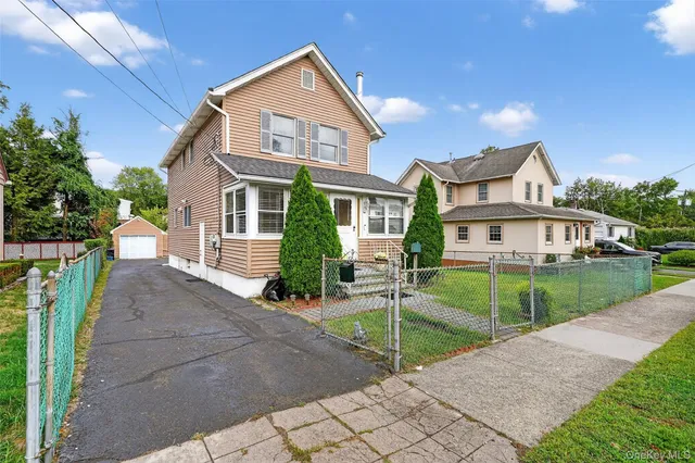 a front view of a house with a yard and potted plants