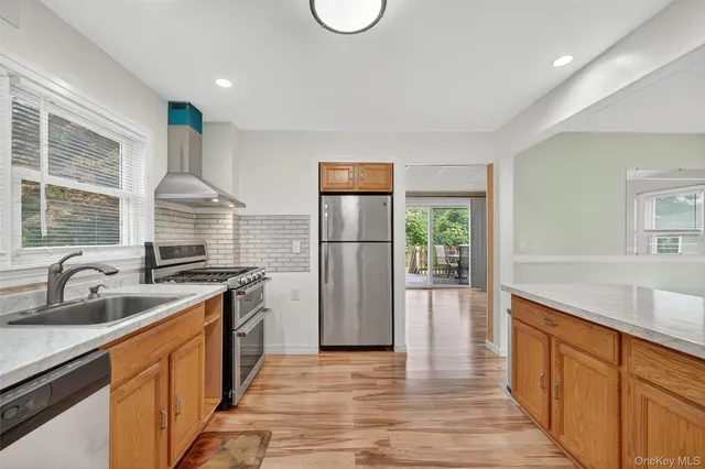 a kitchen with stainless steel appliances granite countertop a sink stove and refrigerator
