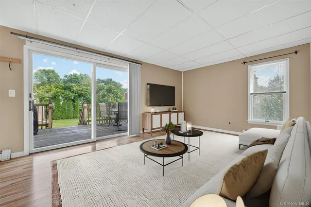 a living room with furniture a flat screen tv and a floor to ceiling window